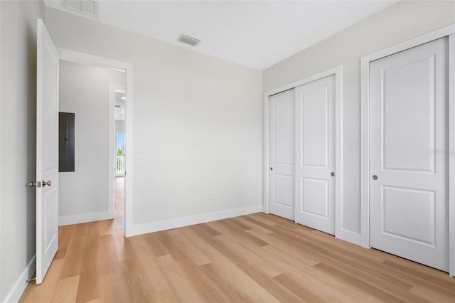 unfurnished bedroom with light hardwood / wood-style floors and electric panel