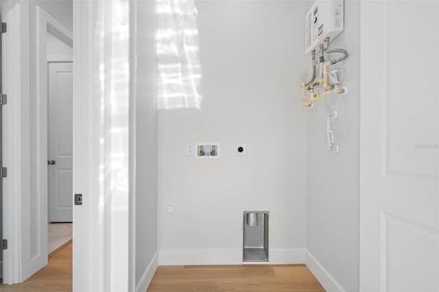 laundry area with hookup for a gas dryer, electric dryer hookup, washer hookup, and light hardwood / wood-style flooring