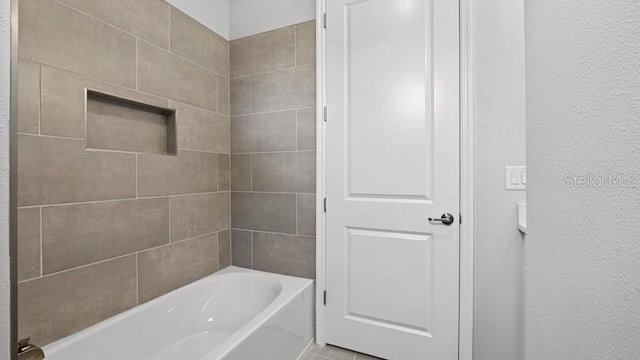 bathroom with tiled shower / bath combo and tile patterned floors