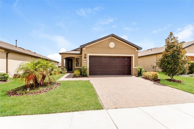 406 Tortosa Ct, Davenport, FL 33837 - single story home featuring stucco siding, decorative driveway, an attached garage, and a front lawn