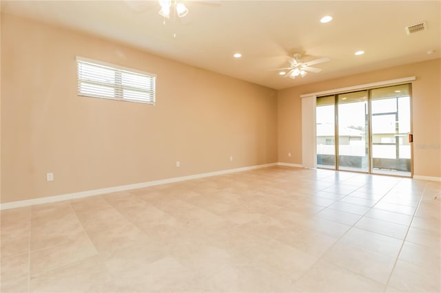 spare room featuring ceiling fan, a healthy amount of sunlight, and light tile patterned floors