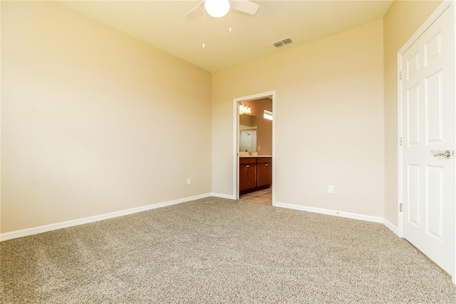 unfurnished bedroom with ceiling fan, connected bathroom, and light colored carpet