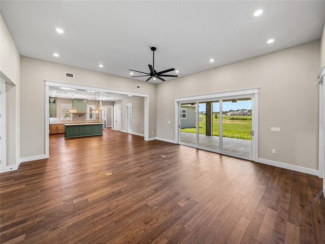 unfurnished living room featuring ceiling fan and hardwood / wood-style floors