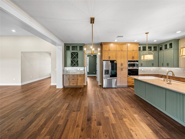 kitchen with dark wood-type flooring, tasteful backsplash, pendant lighting, and stainless steel appliances