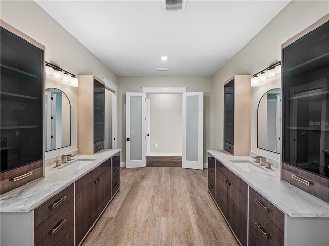 bathroom featuring wood-type flooring and dual vanity