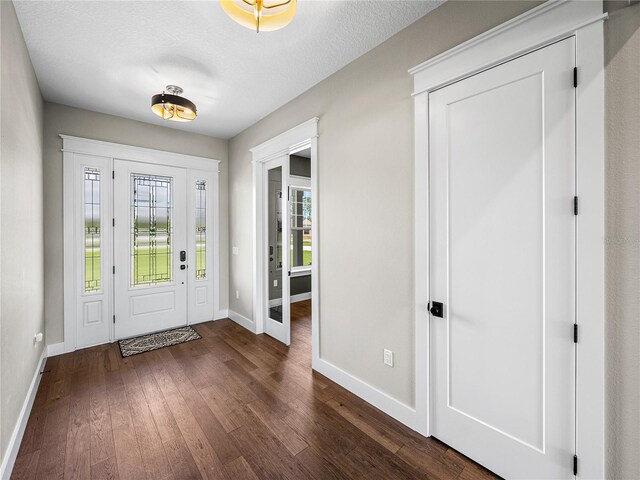 foyer entrance with wood-type flooring and a textured ceiling