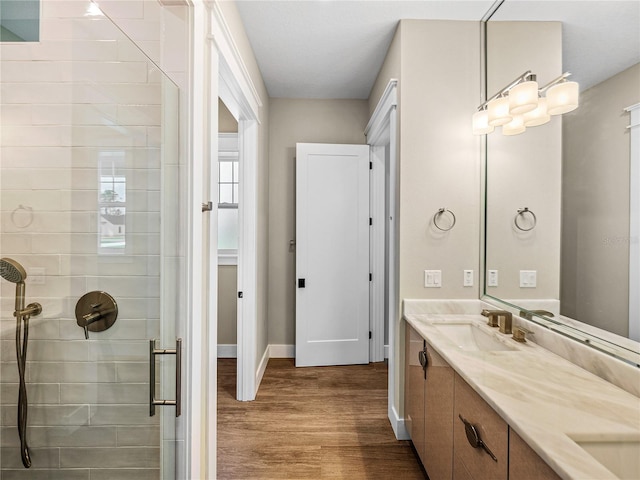 bathroom featuring vanity, a tile shower, and hardwood / wood-style floors