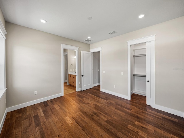 unfurnished bedroom with hardwood / wood-style flooring, connected bathroom, and a closet