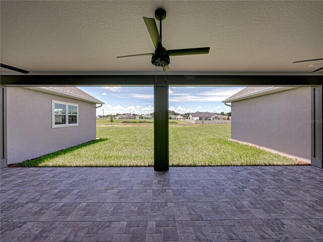 unfurnished sunroom featuring ceiling fan