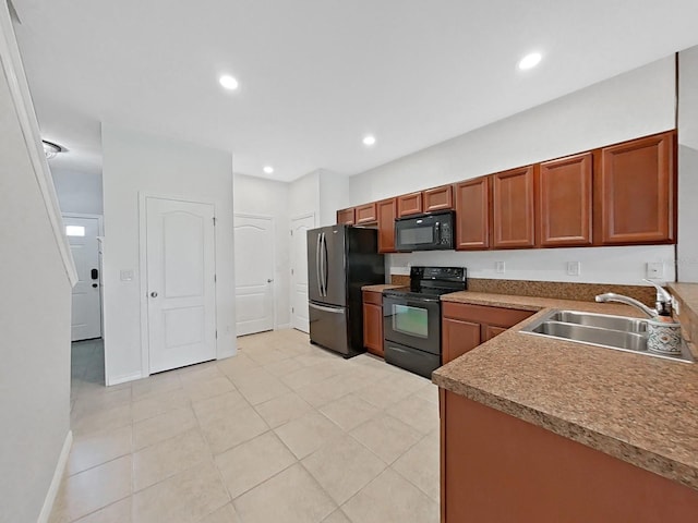 kitchen featuring sink, light tile patterned floors, and black appliances