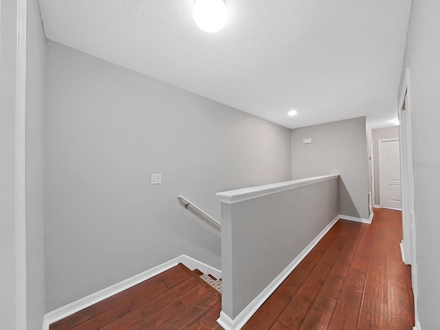 hall with hardwood / wood-style flooring and a textured ceiling