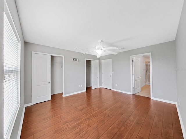 unfurnished bedroom with hardwood / wood-style flooring, ceiling fan, and ensuite bath