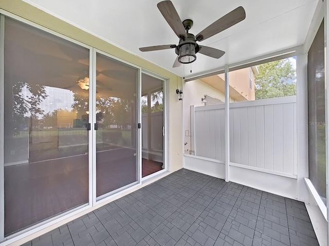 unfurnished sunroom with ceiling fan