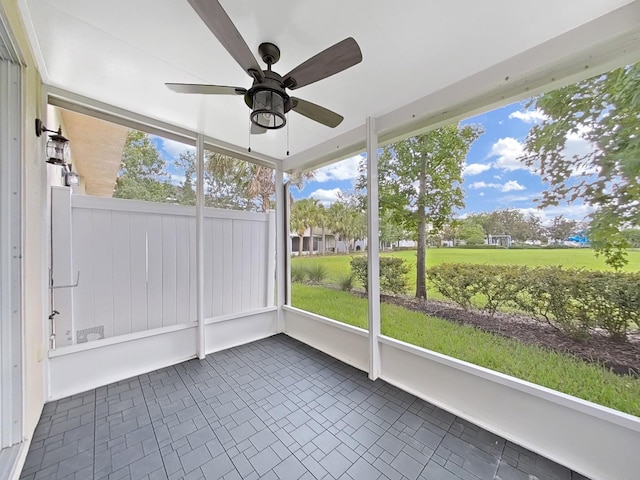 unfurnished sunroom featuring ceiling fan