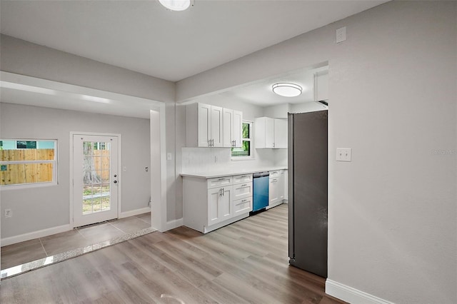 kitchen featuring white cabinetry, stainless steel appliances, decorative backsplash, and light wood-type flooring