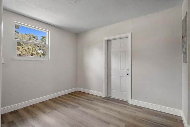 empty room with a textured ceiling and hardwood / wood-style flooring