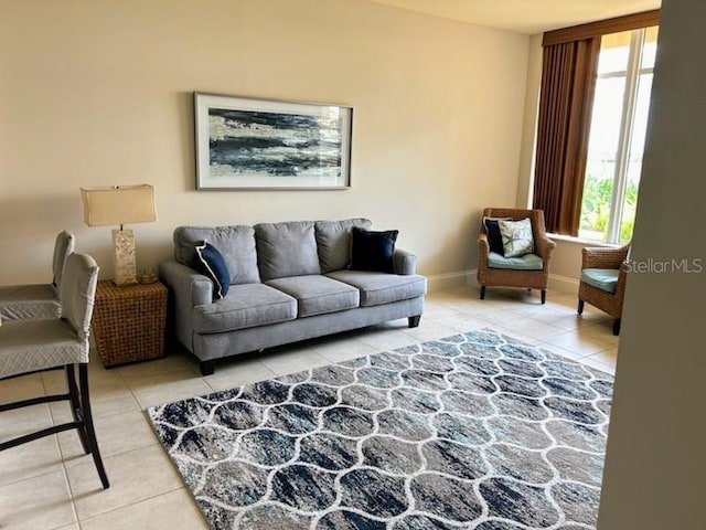 living area with baseboards and light tile patterned floors