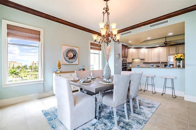 dining room with visible vents, baseboards, crown molding, and ceiling fan with notable chandelier
