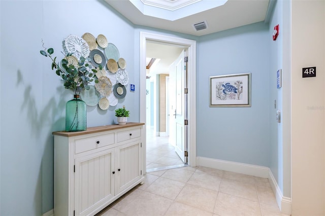 hallway featuring baseboards, visible vents, a skylight, and light tile patterned flooring