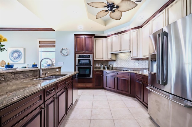 kitchen with light tile patterned floors, a sink, a ceiling fan, appliances with stainless steel finishes, and backsplash