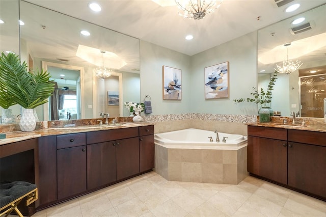 bathroom with a sink, an inviting chandelier, two vanities, a garden tub, and tile patterned flooring