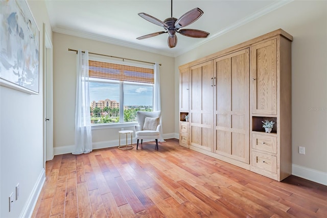 living area with crown molding, ceiling fan, and light wood-style floors