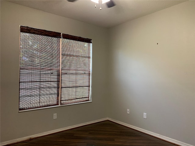 spare room featuring dark hardwood / wood-style flooring and ceiling fan