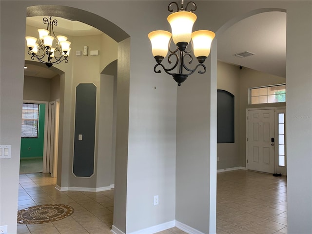 hall featuring an inviting chandelier and light tile patterned flooring