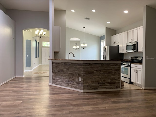 kitchen with a chandelier, stainless steel appliances, a healthy amount of sunlight, and dark hardwood / wood-style floors