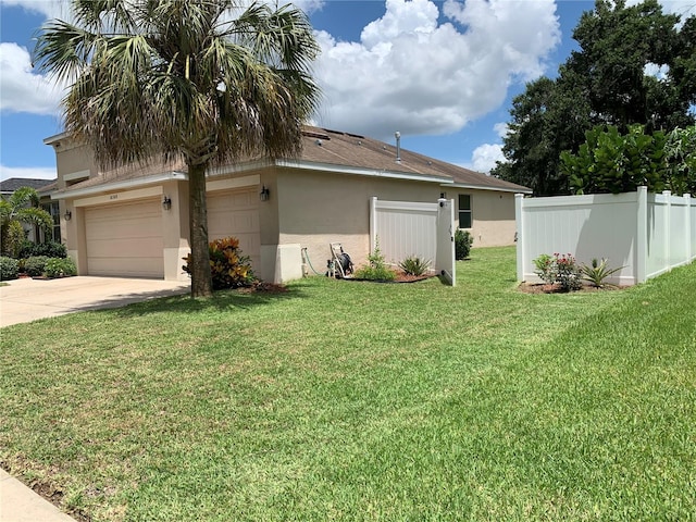 view of front of house featuring driveway, fence, a front lawn, and stucco siding