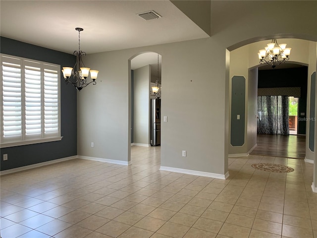 tiled empty room with a chandelier