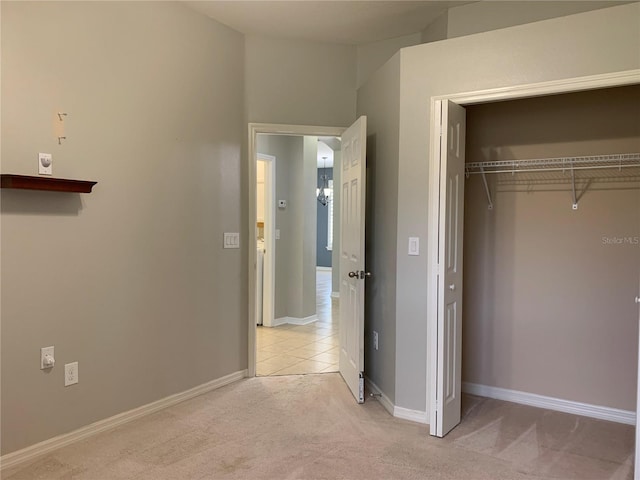 unfurnished bedroom featuring a closet and light carpet