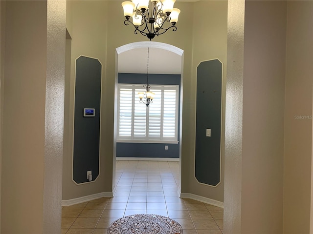 corridor featuring a chandelier and light tile patterned flooring