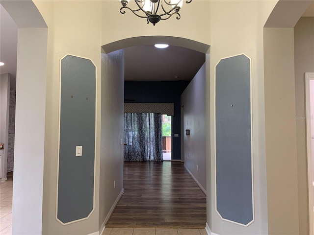 hallway with a notable chandelier and hardwood / wood-style flooring