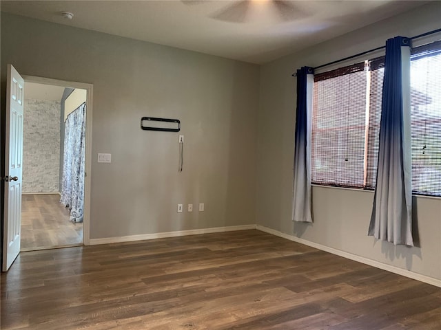 spare room featuring ceiling fan and dark hardwood / wood-style floors