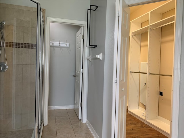 bathroom featuring a shower with door and wood-type flooring