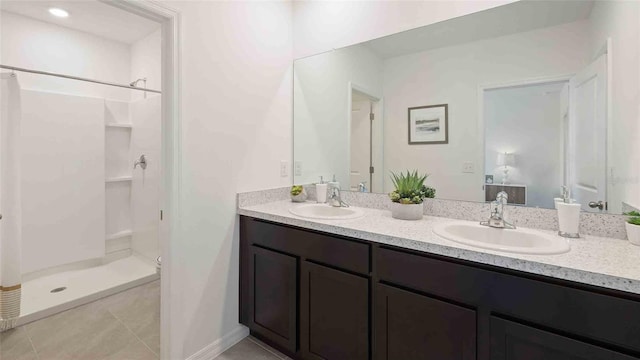 bathroom with a shower, vanity, and tile patterned flooring