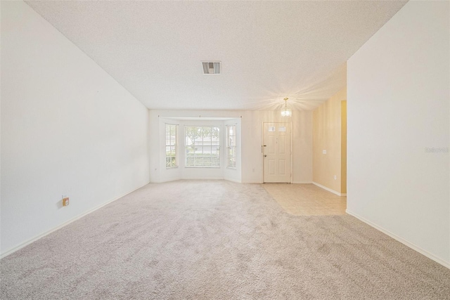 carpeted spare room featuring a textured ceiling