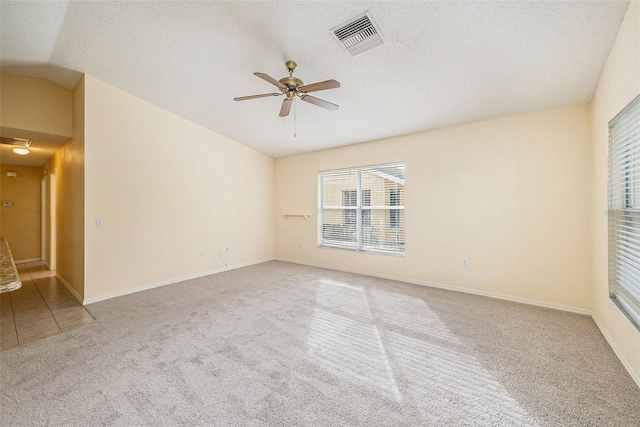 carpeted empty room featuring ceiling fan, a textured ceiling, and vaulted ceiling