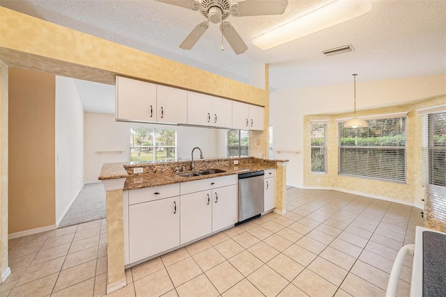 kitchen with pendant lighting, sink, stainless steel dishwasher, and a textured ceiling