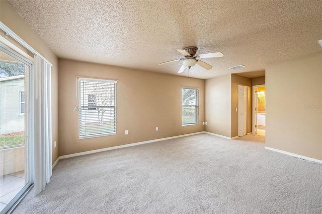 carpeted empty room featuring ceiling fan and a textured ceiling