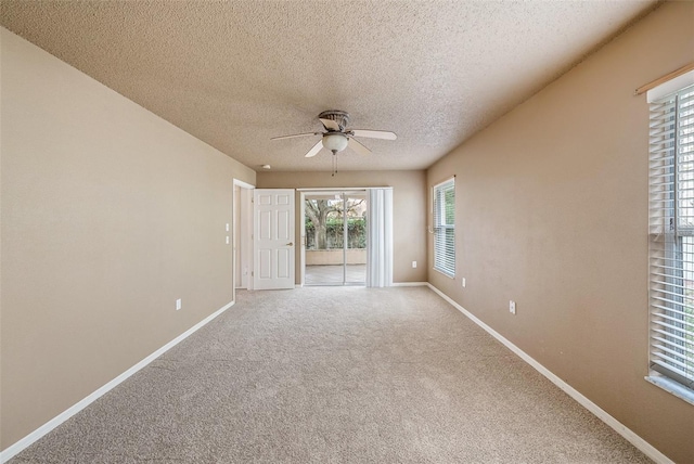 carpeted spare room with ceiling fan and a textured ceiling