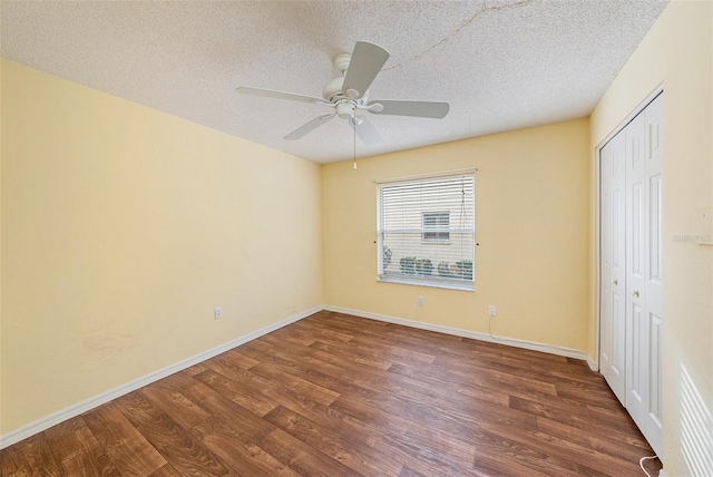 unfurnished bedroom featuring ceiling fan, dark hardwood / wood-style floors, a textured ceiling, and a closet