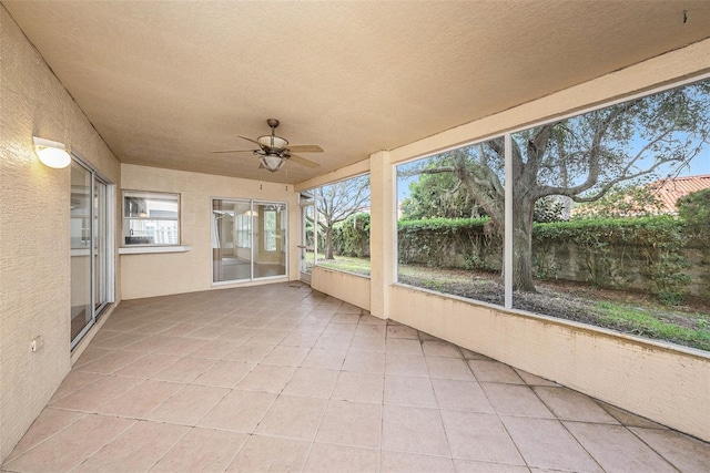 unfurnished sunroom featuring ceiling fan