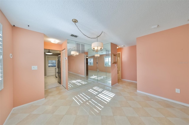 spare room featuring a textured ceiling and light tile patterned floors