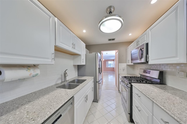 kitchen featuring sink, tasteful backsplash, white cabinets, and stainless steel appliances