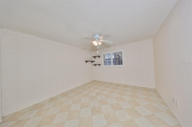 empty room featuring a textured ceiling, ceiling fan, and light tile patterned floors