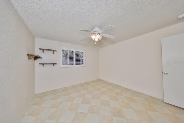 tiled spare room featuring a textured ceiling and ceiling fan