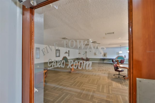 carpeted office space with a textured ceiling