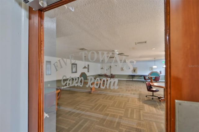 interior space featuring parquet flooring and a textured ceiling